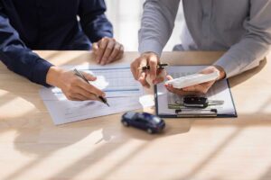 A homeowner reviews an insurance policy beside jewelry appraisal documents and household records.